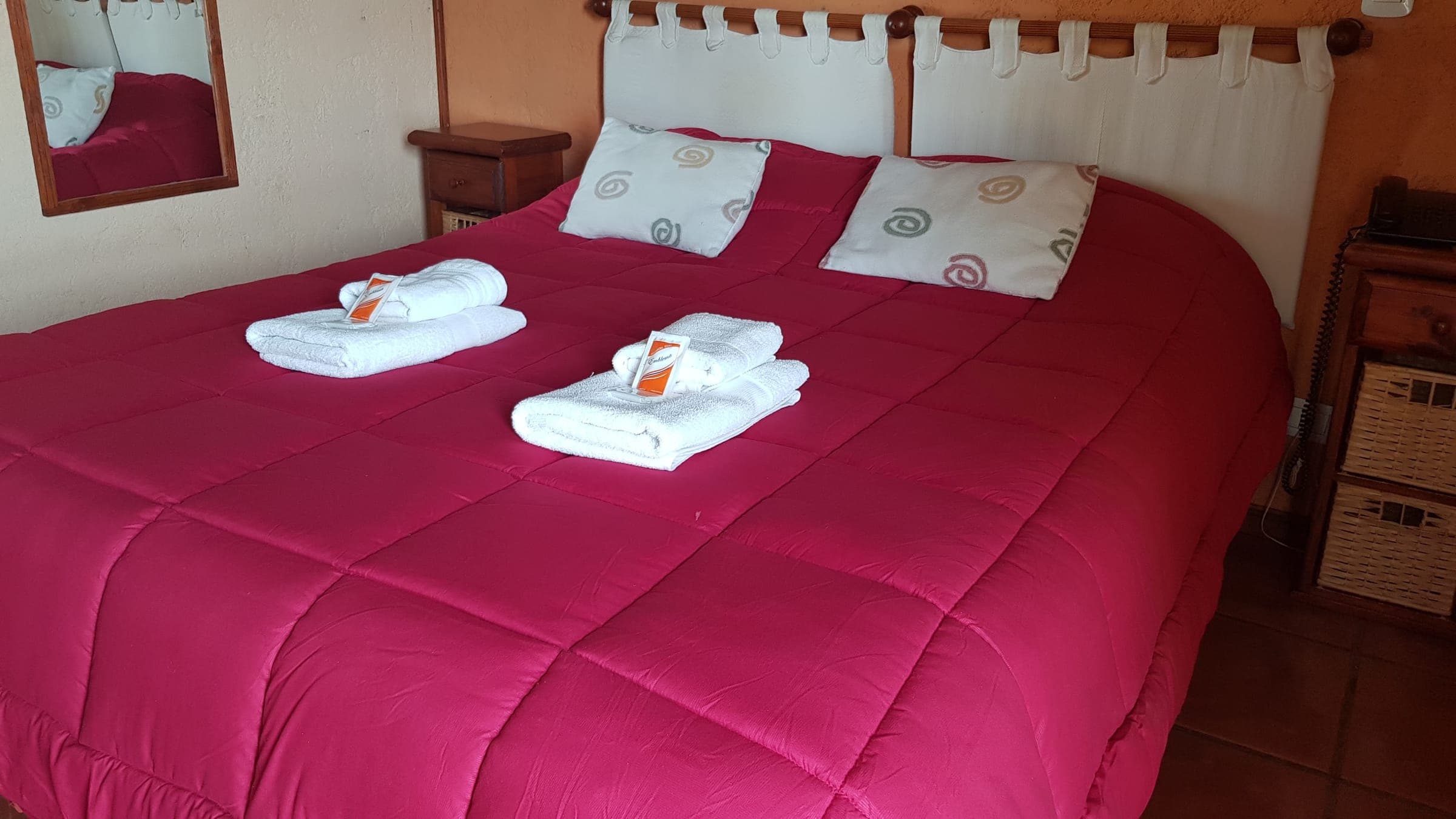 Habitación matrimonial con cama grande y mesas de luz